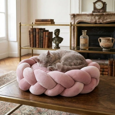 chat enroulé en boule dans couffin pour chat rose poudré