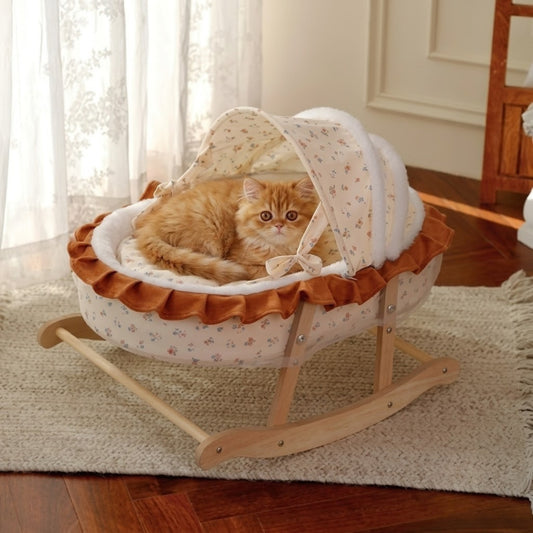 Couffin chaton roux lové sous l'arceau fleuri sur cadre bois
