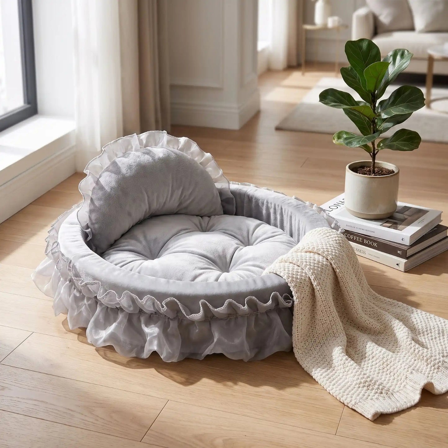 Couffin pour chaton gris à dossier haut, bordé de dentelle et organza, dans un salon lumineux