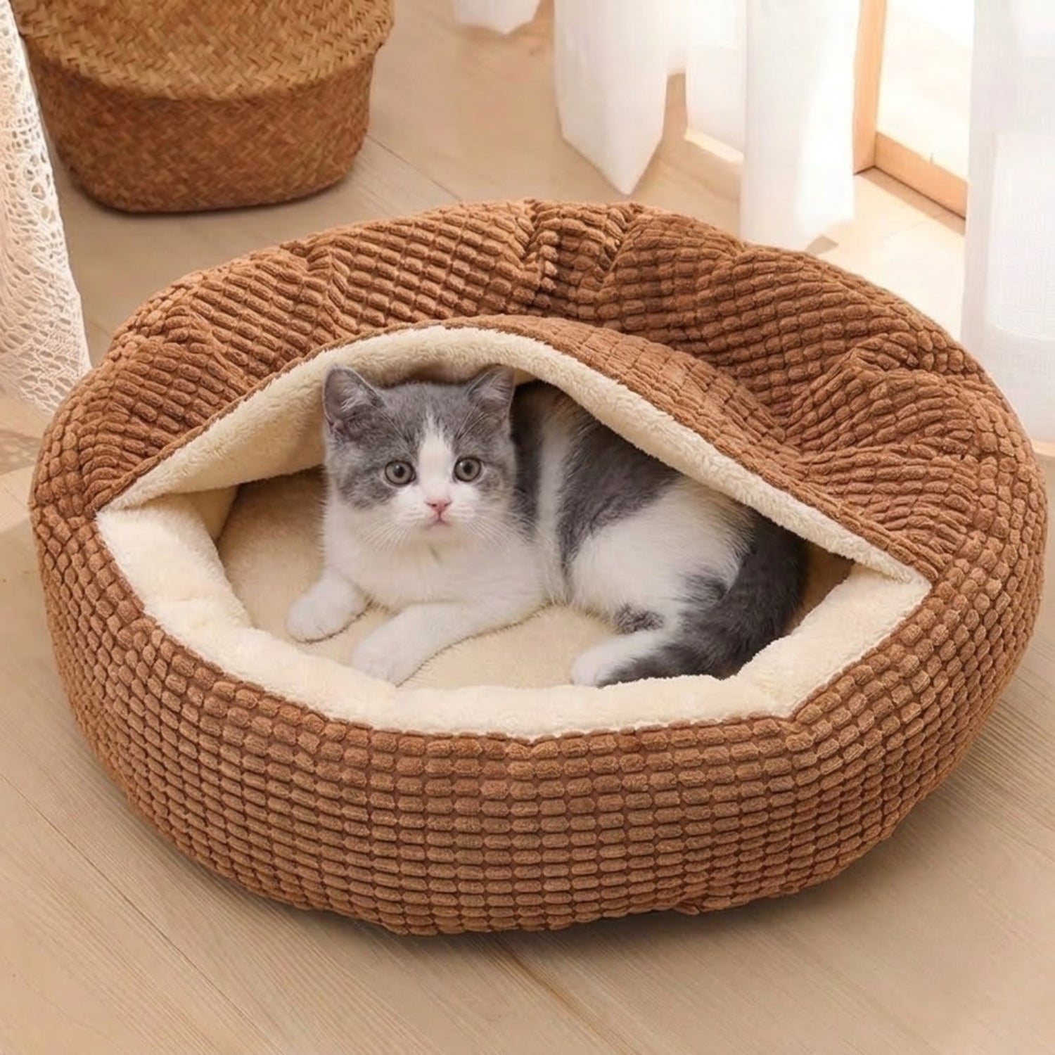 Couffin pour chaton marron, lové sous la capuche souple