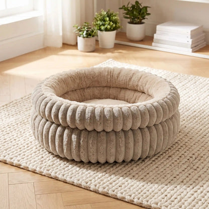 coussin pour chaton beige taupe posé sur tapis crème dans un salon clair