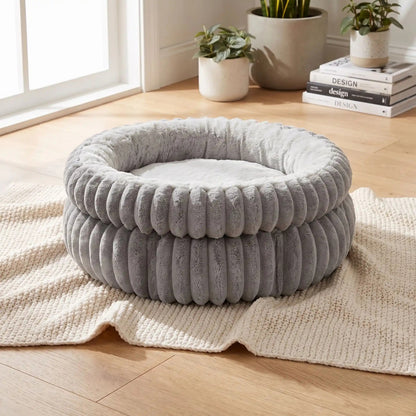 coussin pour chaton gris perle posé sur tapis crème dans un salon clair