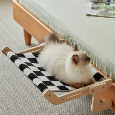 ragdoll en detente sur hamac chat suspendu au bord lit